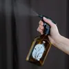 Person spraying brown bottle in a room