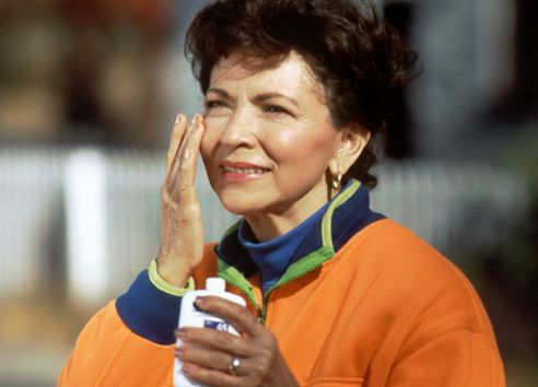 Woman applying sun cream onto her face