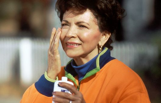 Woman applying sun cream onto her face