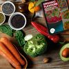 Ariel view of kitchen table scattered with vegetables and Organic Flavours eBook displaying on tablet screen