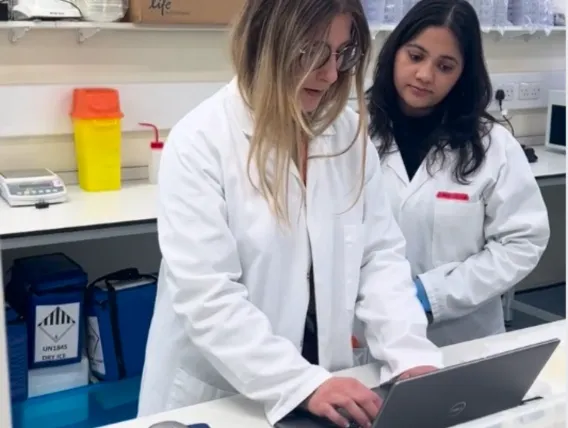 Two women in science lab looking at computer
