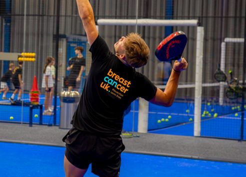 Action shot of young man serving on padel court