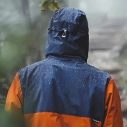 Person in navy raincoat in the rain
